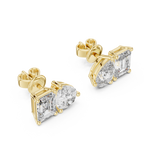 Yellow gold dual stone stud earrings close up emerald and pear cut