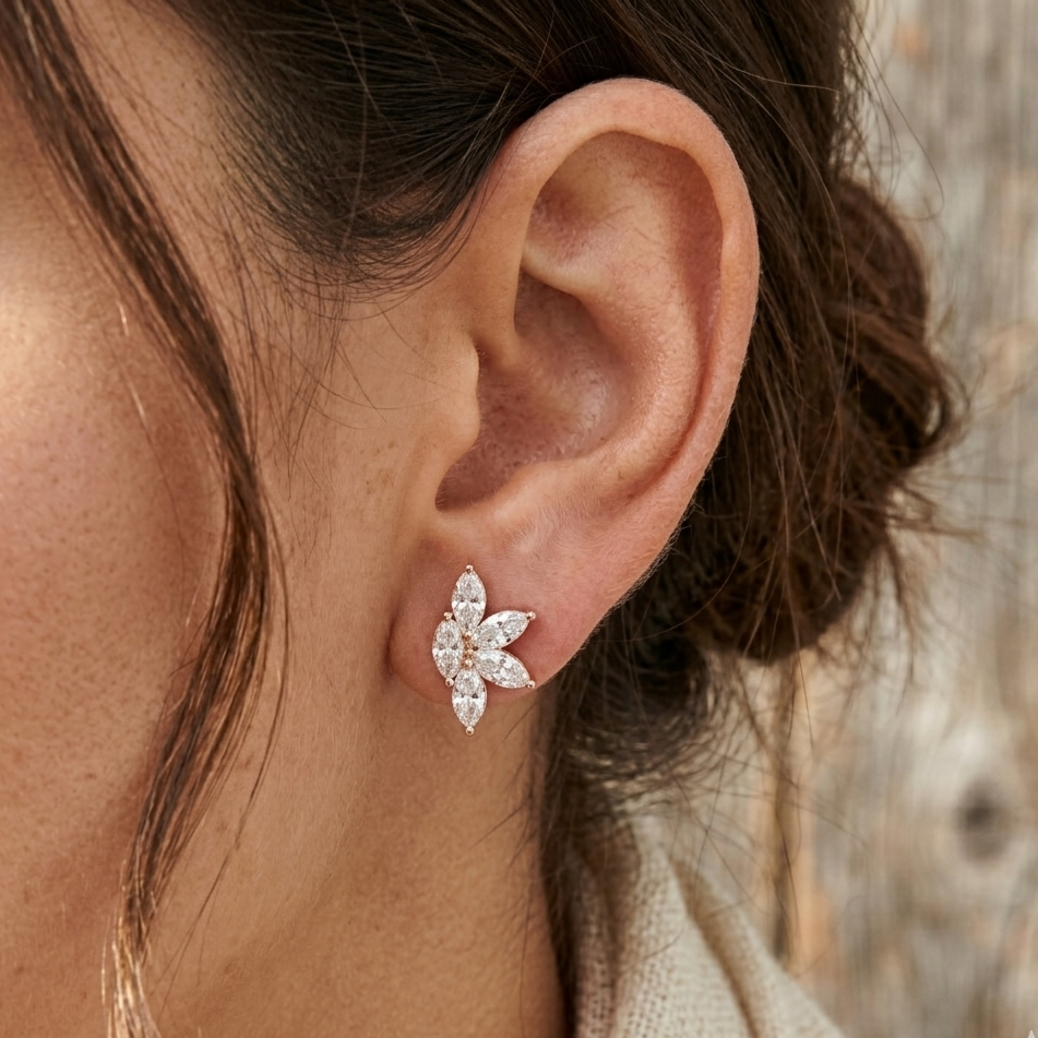 Close-up of an ear wearing a diamond earring with a blurred natural background
