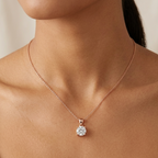 Rose gold necklace with a diamond pendant on a model against a neutral background