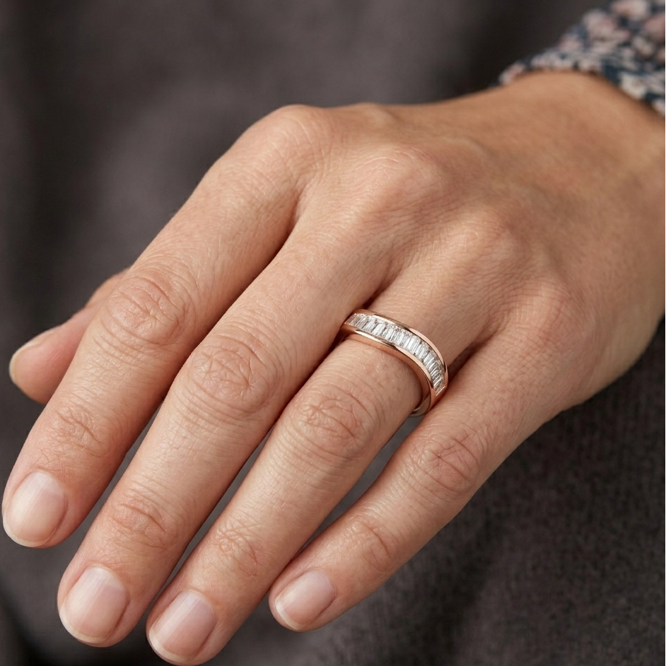 Hand wearing a diamond ring on a neutral background