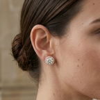 Close-up of a woman wearing a diamond earring with a neutral background