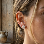 Close-up of a woman wearing star-shaped earrings with a wooden background