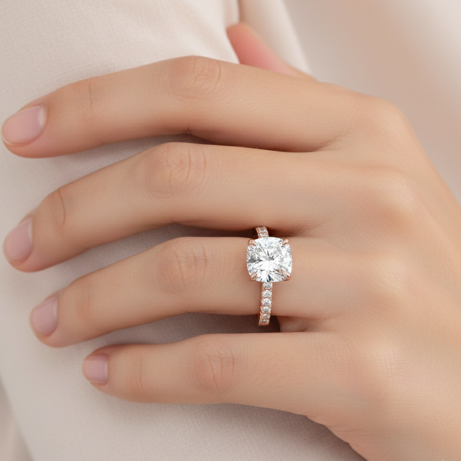 Rose gold diamond ring on a hand against a light background