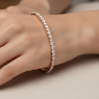 Hand wearing a delicate bracelet on a neutral background